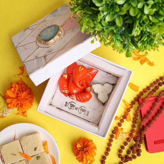 Orange Ganesha on Marble Chowki
