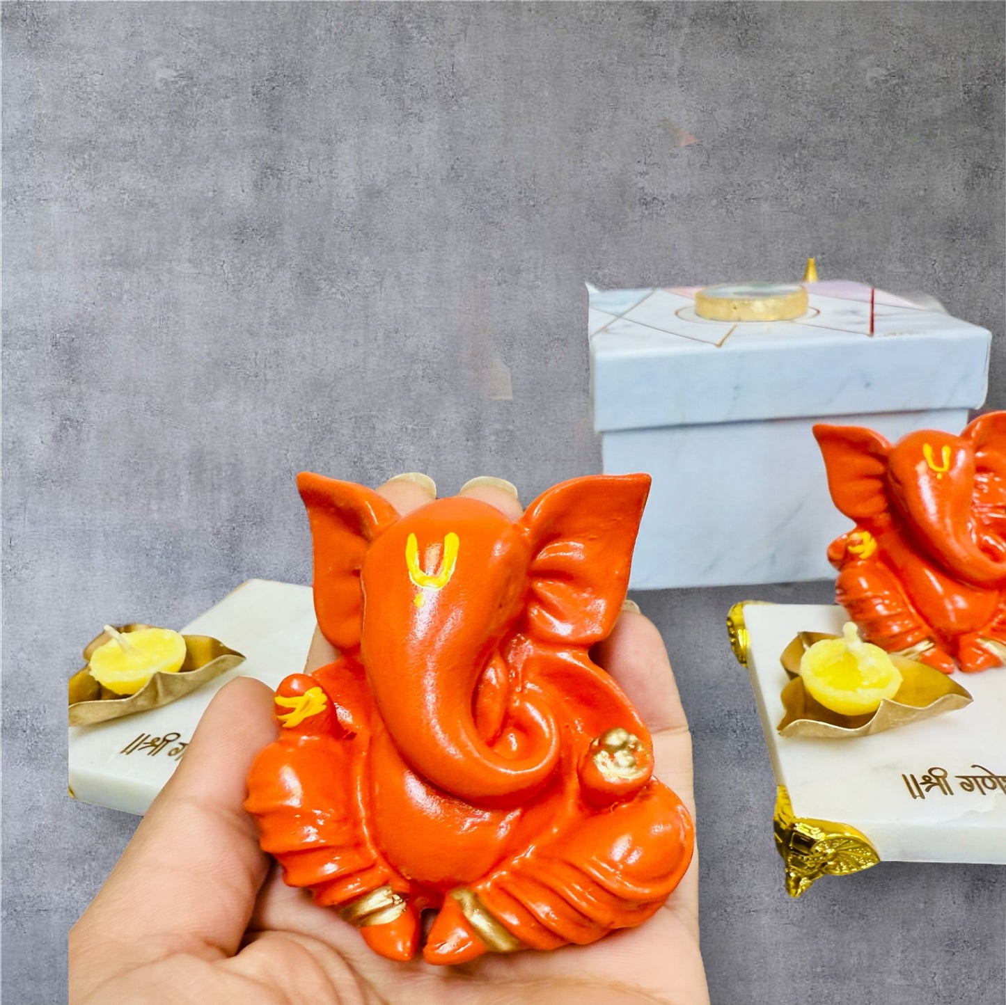Orange Ganesha on Marble Chowki