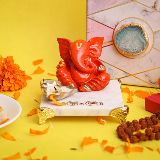 Orange Ganesha on Marble Chowki