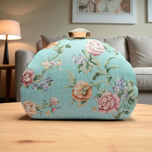 Floral-patterned clutch bag on a wooden surface with a blurred indoor background