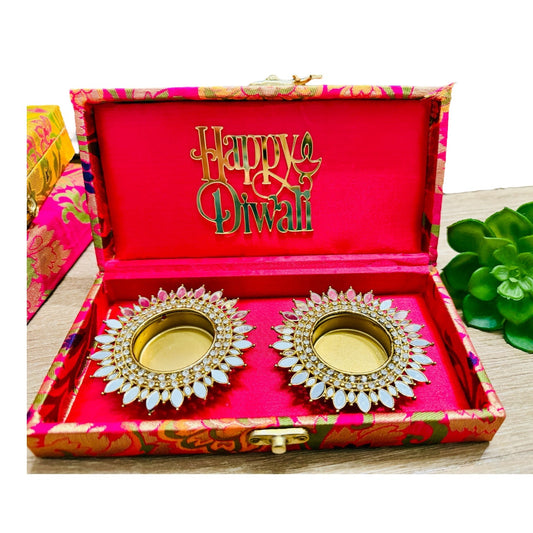 Decorative oil lamps in a 'Happy Diwali' box with a pink interior.