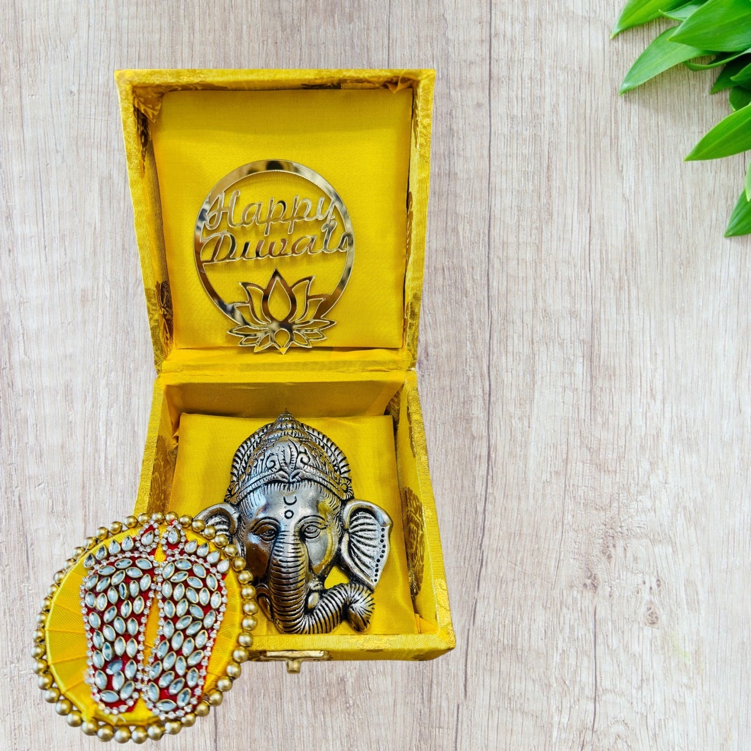 Decorative item with 'Happy Diwali' message in a yellow box on a light wooden surface.